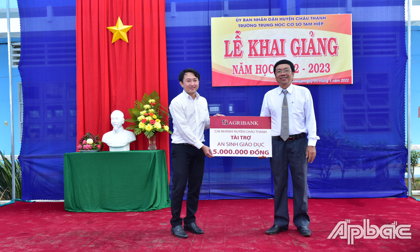 Đại diện Agribank huyện Châu Thành trao biển tượng trưng số tiền ủng hộ cho đại diện Trường Trung học cơ sở Tam Hiệp