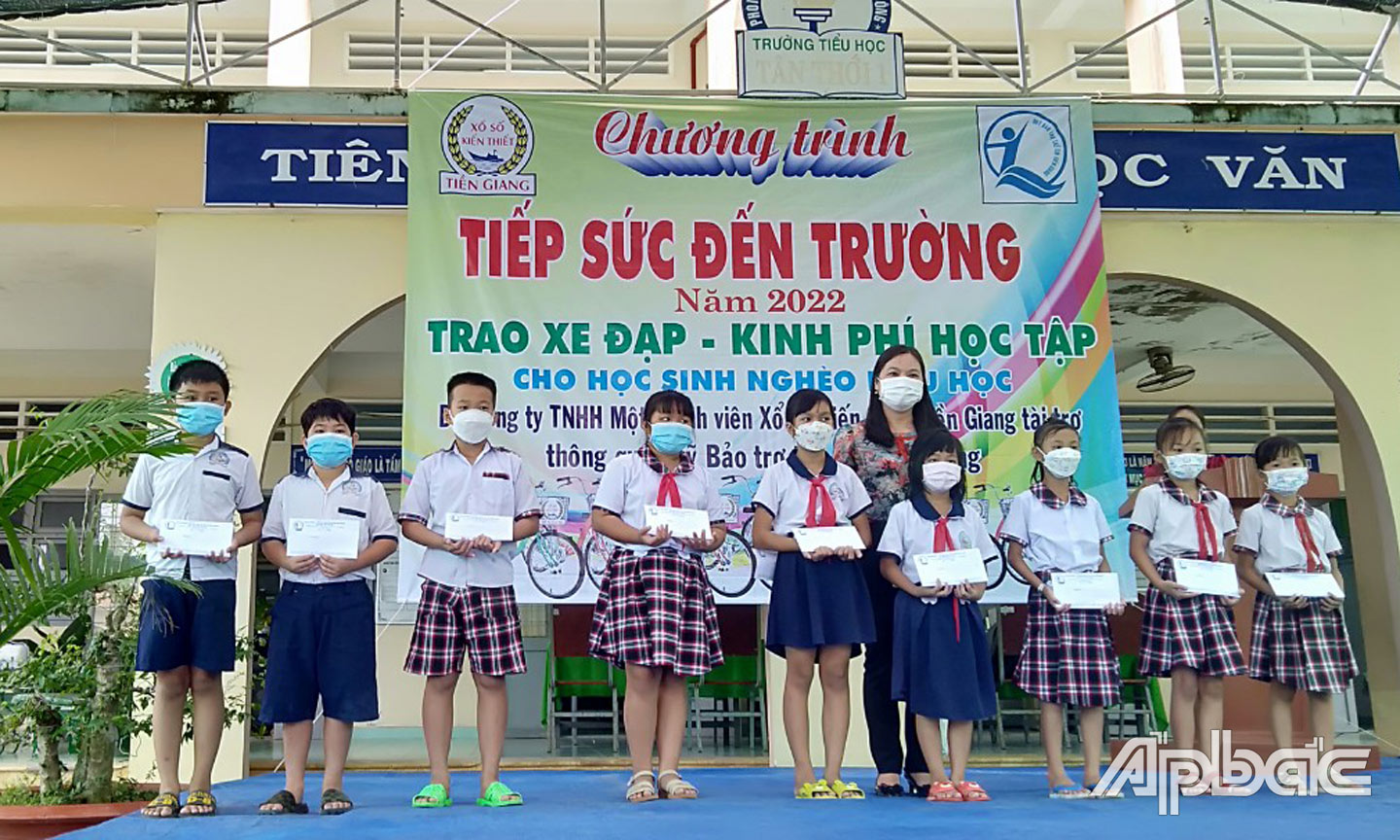 Bà Võ Thị Nguyệt Nga, Ủy viên BCH Công đoàn  Công ty TNHH MTV Xổ số kiến thiết Tiền Giang trao quà cho các em học sinh.