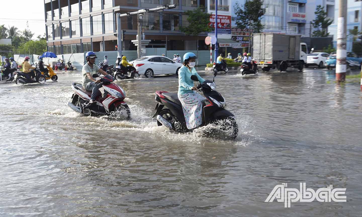 Nước ngập gây khó khăn cho người dân di chuyển qua ngã 4 Hùng Vương - Lê Văn Nghề (xã Đạo Thạnh, TP. Mỹ Tho).