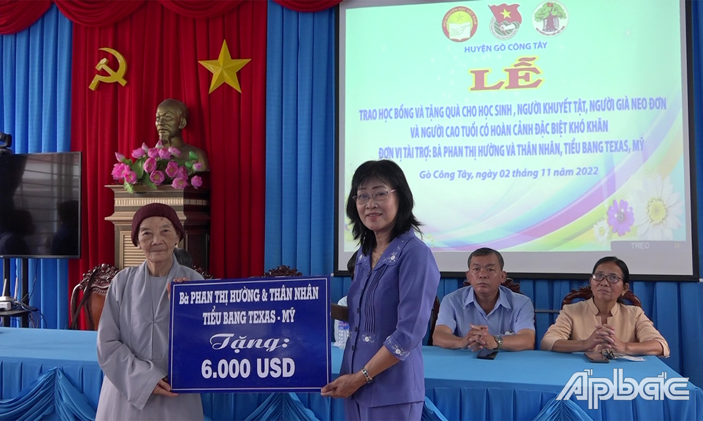 chủ tịch Hội Khuyến học huyện Nguyễn Thị Mỹ Hoa nhận bảng tượng trưng nhận số tiền hỗ trợ trị giá 6.000 USD từ nhà tài trợ                                                  