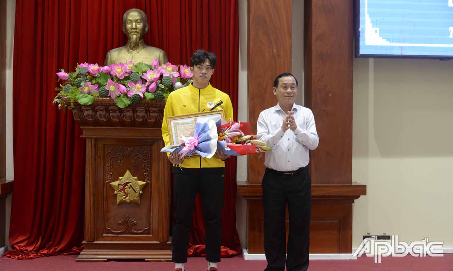 Đồng chí Nguyễn Văn Vĩnh, Chủ tịch UBND tỉnh (bìa phải) trao bằng khen cho VĐV Phạm Minh Bảo Kha.