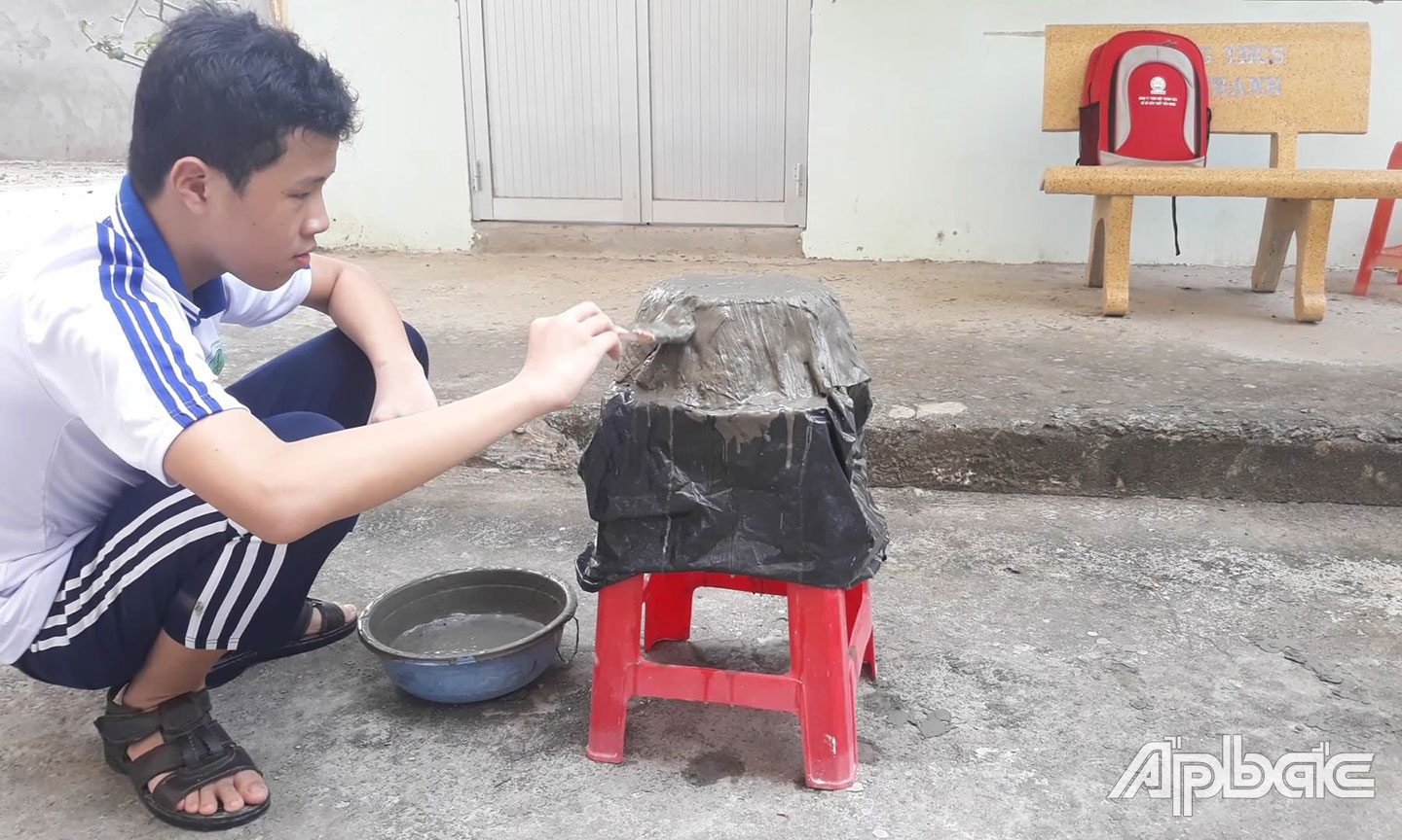 Em Cao Hữu Tín đang tạo hình chậu kiểng từ khẩu trang tái chế.