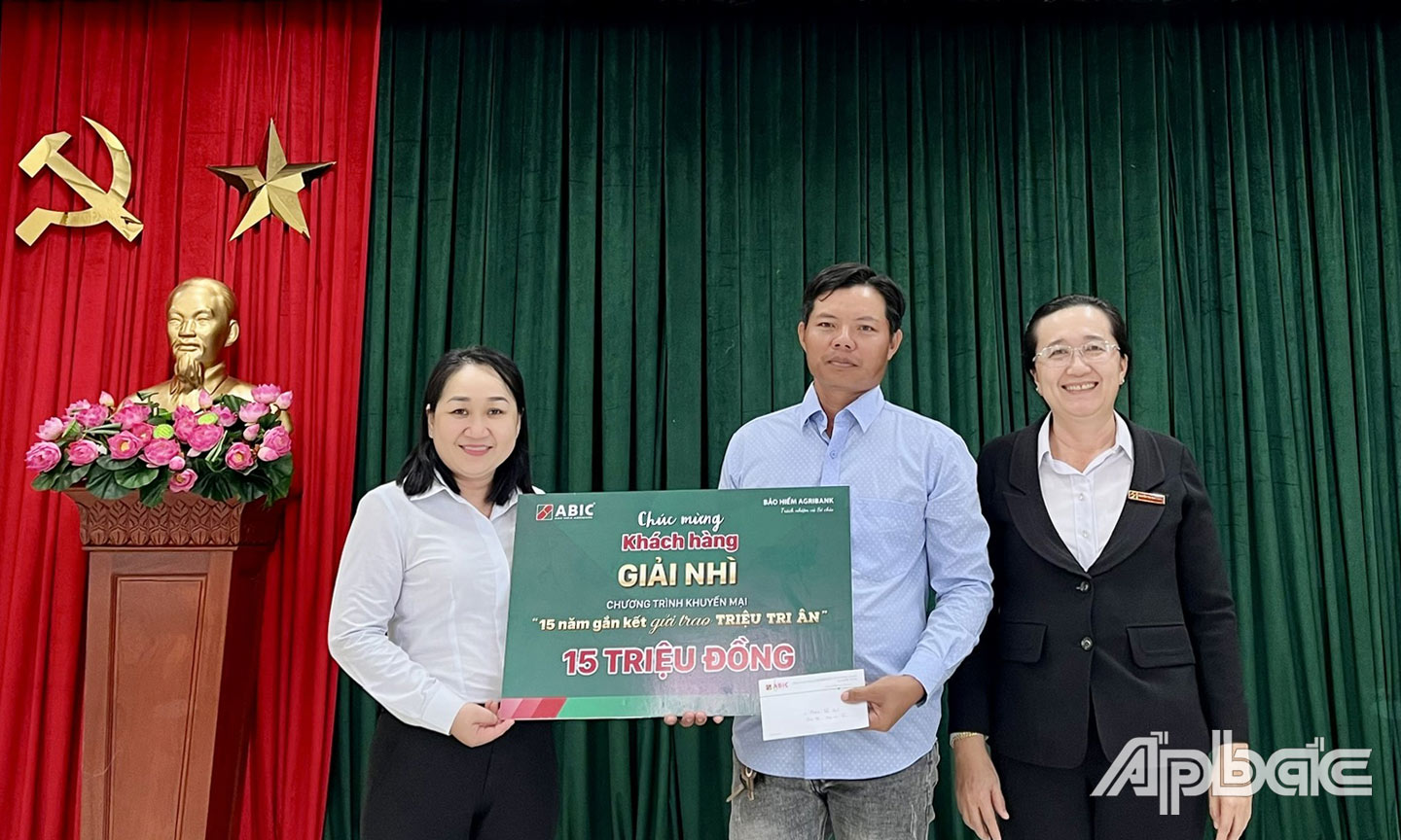 Bà Lê Thị Ngọc Sương, Trưởng phòng Kinh doanh ABIC khu vực Tiền Giang (bìa trái) và Giám đốc Agribank Chi nhánh huyện Tân Phước Nguyễn Thị Thúy Hằng (bìa phải) trao giải thưởng cho khách hàng.