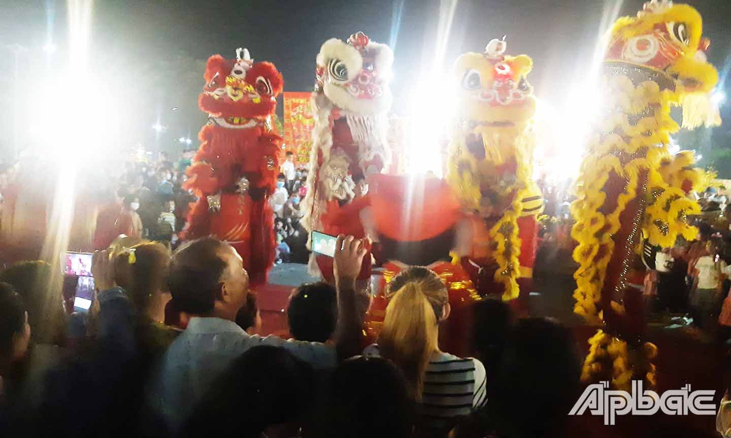 Người dân xem biểu diễn lân sư rồng ở thị trấn Mỹ Phước (huyện Tân Phước).