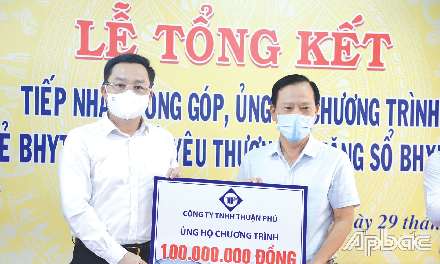 Đồng chí Võ Khánh Bình (bên trái) tiếp nhận kinh phí 100 triệu đồng ủng hộ 2 chương trình: “Hỗ trợ thẻ BHYT - Chia sẻ yêu thương” và  “Tặng sổ BHXH tự nguyện -  Của để dành khi về già” từ Công ty TNHH Thuận Phú. 
