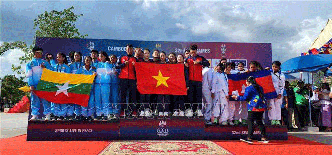 Đội tuyển Đua thuyền Việt Nam (giữa) nhận HCV Đua thuyền truyền thống nội dung thuyền 12 người hỗn hợp cự ly 500m - tấm HCV thứ 2 của Đội tại SEA Games 32. Ảnh: TTXVN