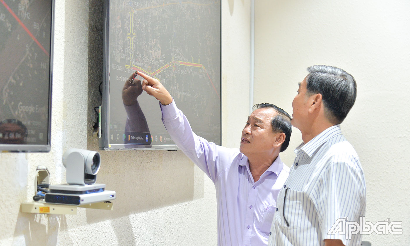 Đồng chí Nguyễn Văn Vĩnh trao đổi với ông Trần Văn Sông về điều chỉnh lại vị trí đoạn Đường tỉnh 864 đang thi công để không di dời cơ sở sản xuất nước đá là không thể thực hiện được.