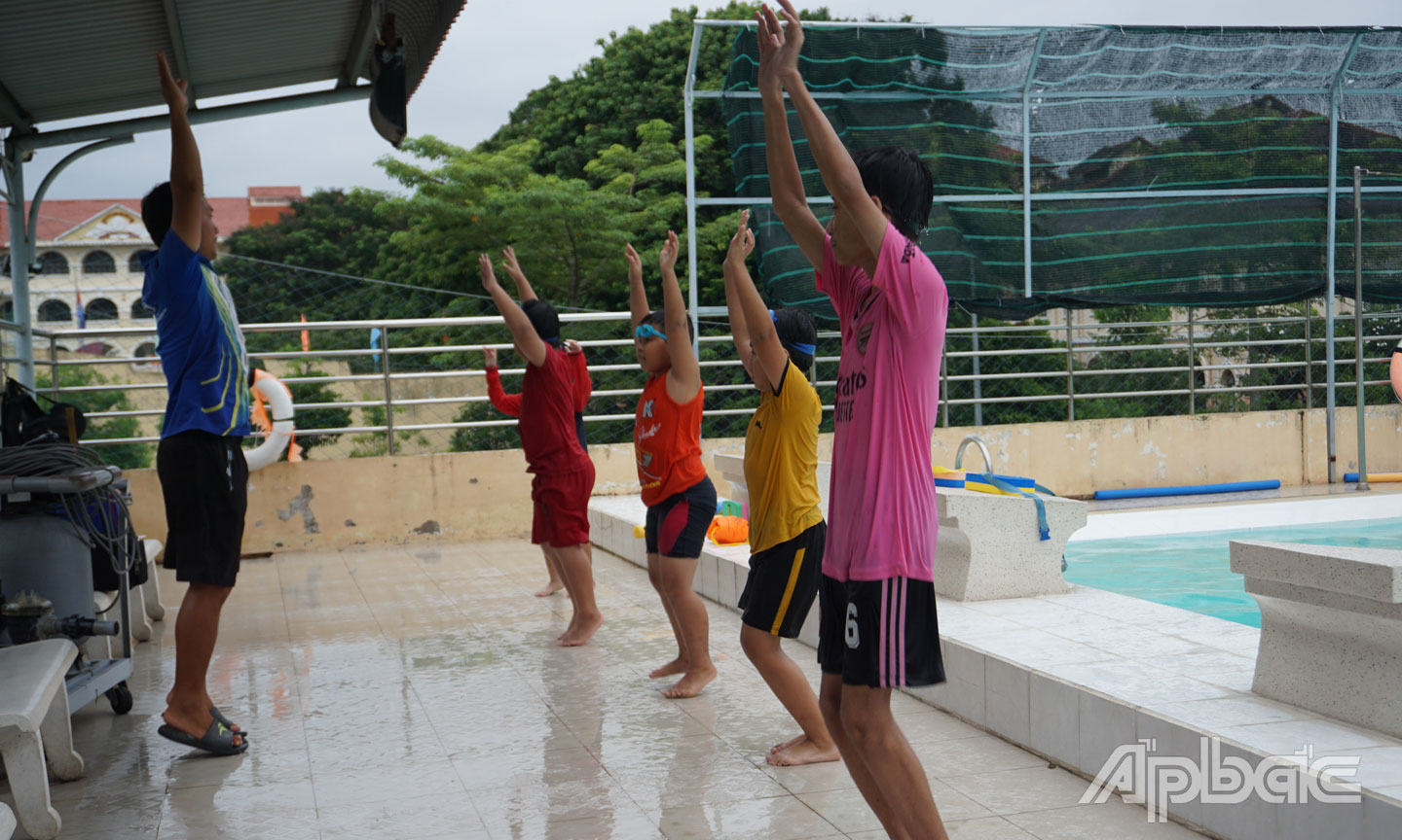 Trẻ học bơi và được hướng dẫn những động tác khởi động trước khi xuống nước.