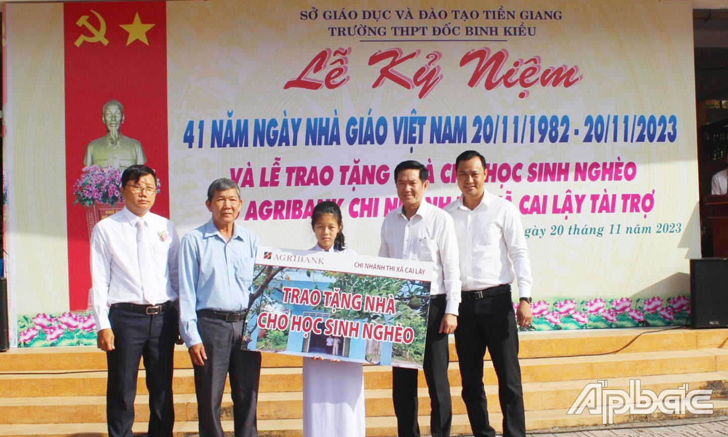 Ông Trương Văn Đoàn, Phó Giám đốc Agribank chi nhánh tỉnh Tiền Giang trao bảng tượng trưng cho em Nguyễn Thị Ngọc Yến với sự chứng kiến của lãnh đạo Ủy ban MTTQ TX. Cai Lậy, cùng lãnh đạo nhà trường.  