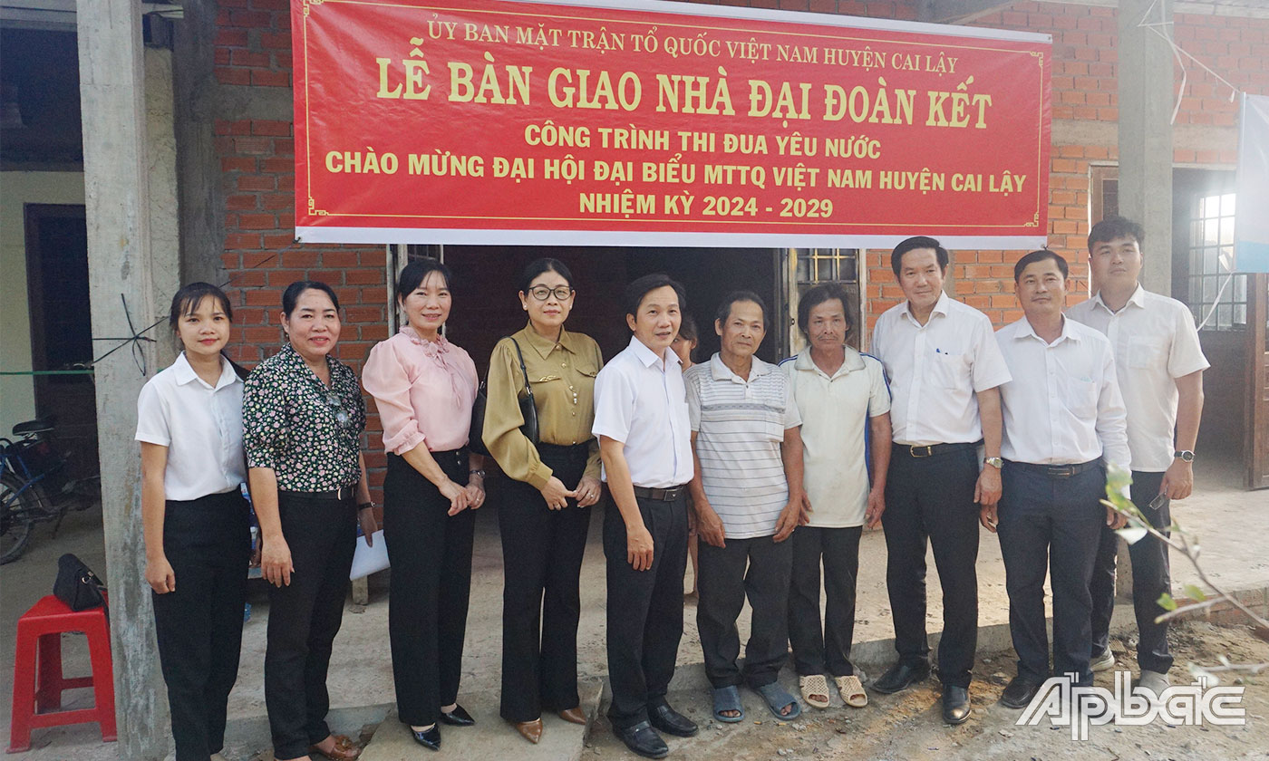 Đại biểu chụp ảnh lưu niệm cùng gia đình ông Nguyễn Văn Mĩnh và ông Nguyễn Văn Phương bên căn nhà mới. 
