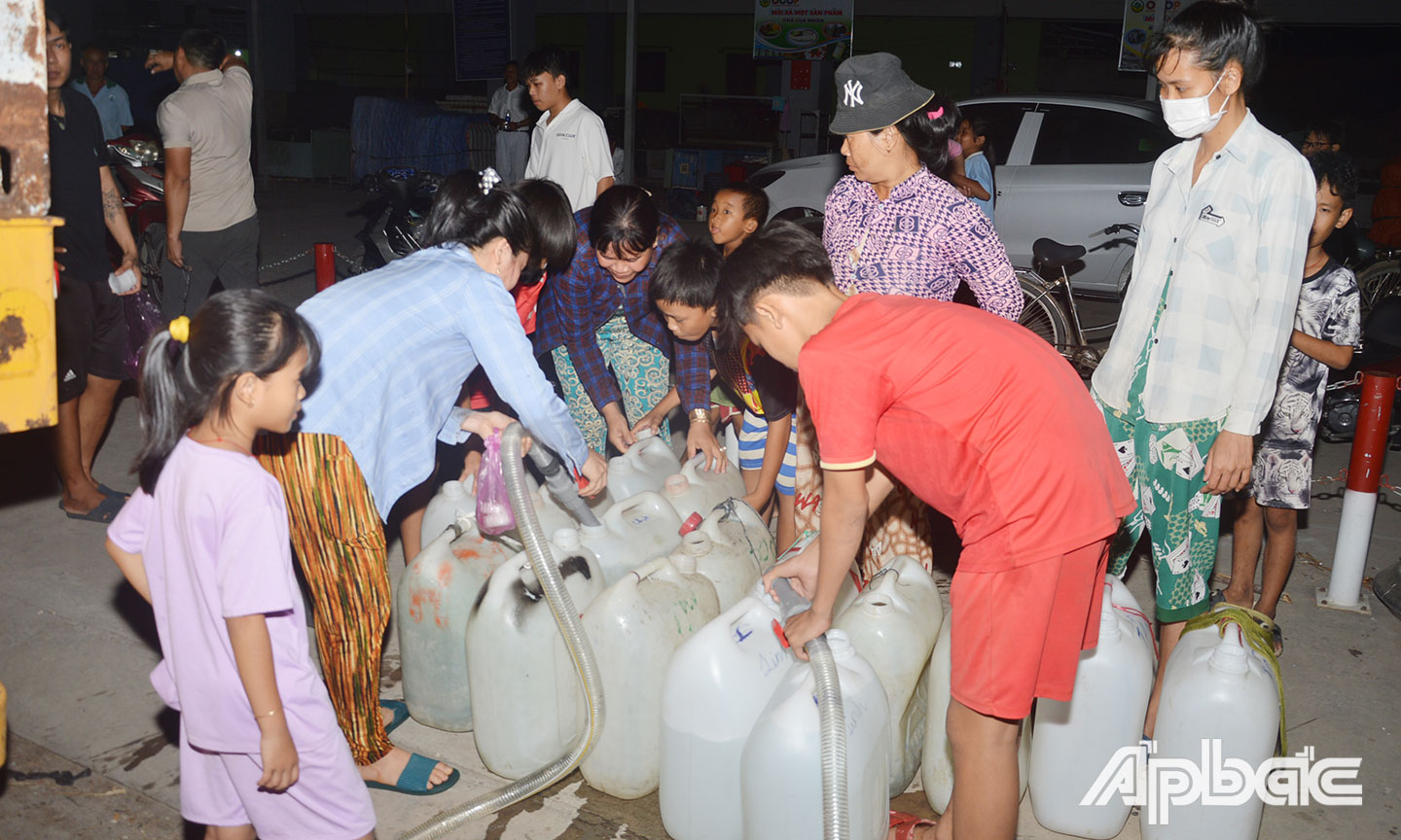Gần 20 giờ ngày 30-3, người dân ở ấp 2, xã Tân Phước, huyện Gò Công Đông vẫn tập trung rất đông để lấy nước từ các xe bồn chở nước từ thiện.