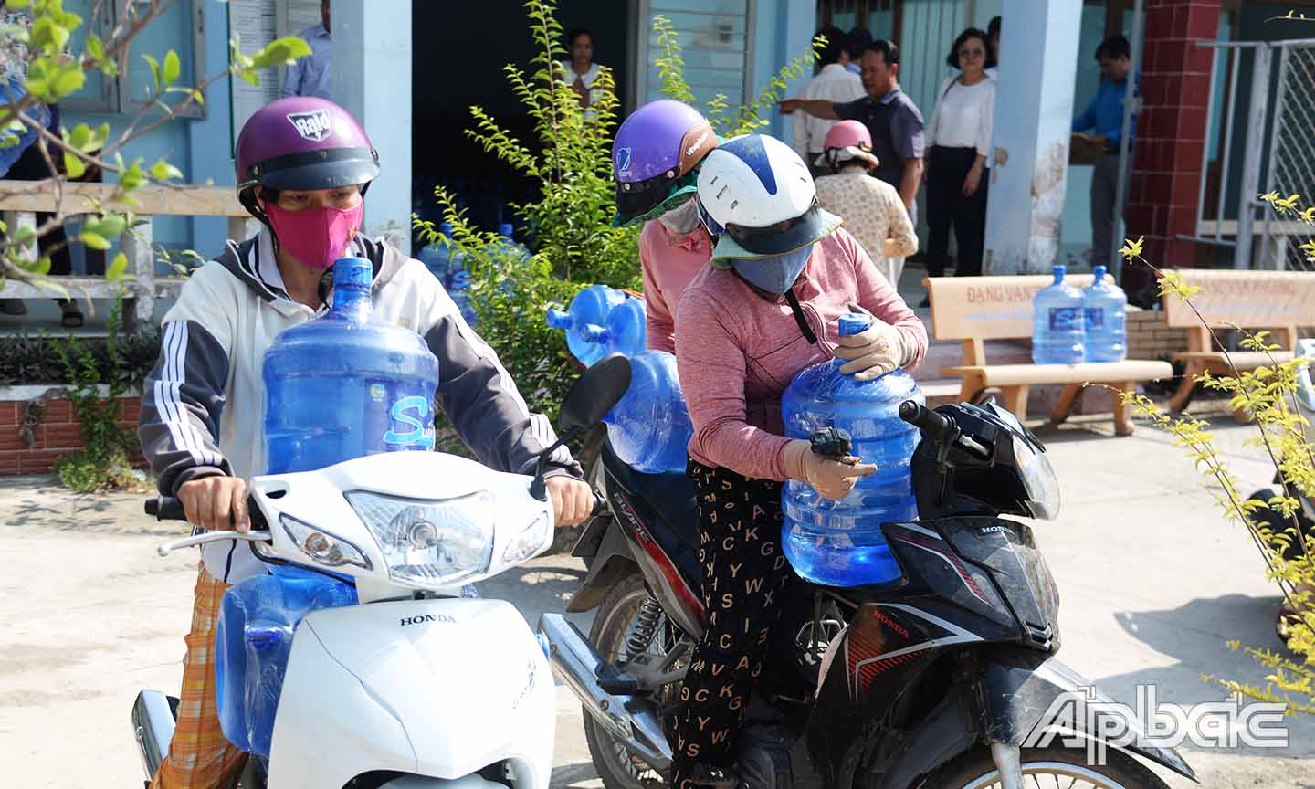Người dân xã Bình Ân vận chuyển nước uống miễn phí về nhà.