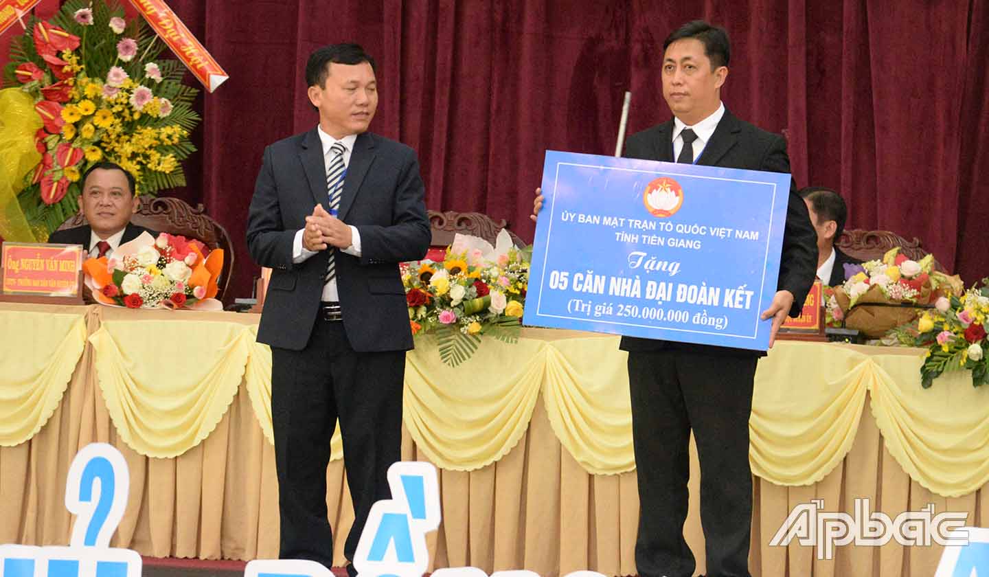 Đồng chí Trần Văn Thi tặng Bảng tượng trưng tặng 5 căn nhà Đại đoàn kết cho Ủy ban MTTQ huyện Tân Phước.