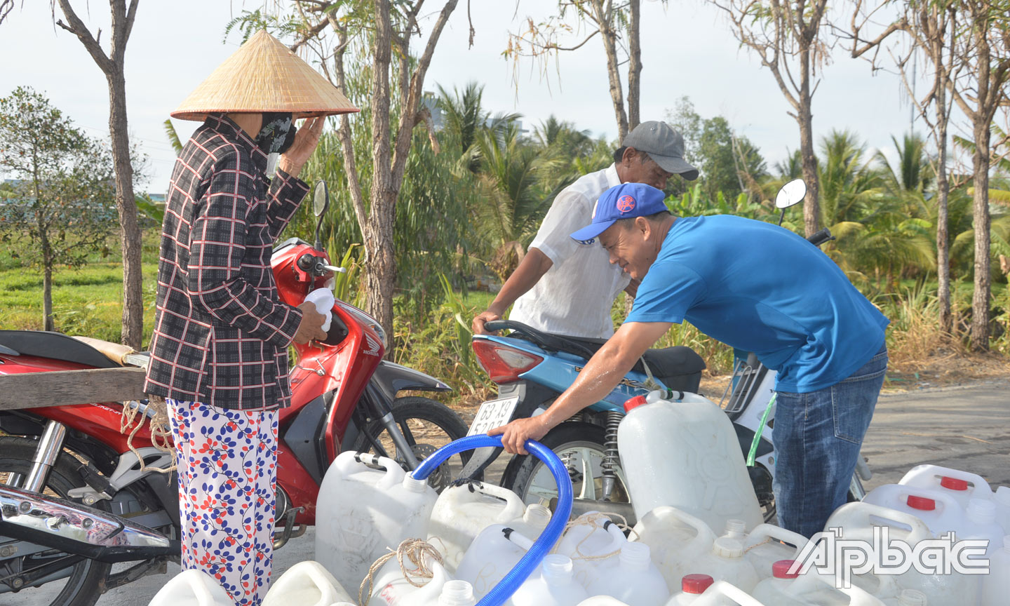 Hầu như ngày nào anh Đinh Nguyễn Công Khanh (mặc áo xanh bìa phải, xã Mỹ Tịnh An, huyện Chợ Gạo) cũng chở 2 xe tải nước sinh hoạt đến xã Tân Phước, huyện Gò Công Đông) để hỗ trợ người dân nơi đây.