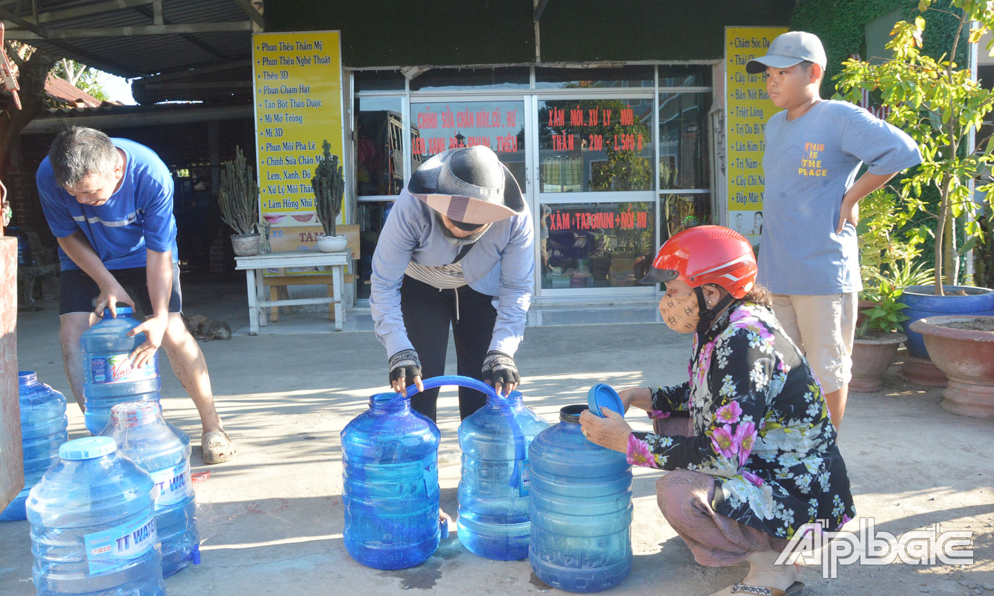 Ngoài hỗ trợ nước sinh hoạt, các nhà hảo tâm còn hỗ trợ nước uống cho người dân. Trong ảnh, bà Kim Thị Mai (chủ khu nhà trọ  ở TP. Bến Cát, tỉnh Bình Dương) mang nước uống đóng bình đến  hỗ trợ cho người dân xã Tăng Hòa, huyện Gò Công Đông.