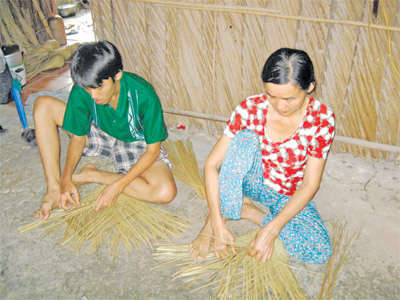 Ngoài giờ học, Thành còn phụ mẹ đan nón.