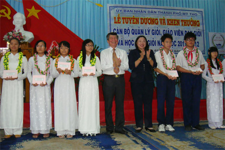 Bà Trần Kim Mai, Phó Chủ tịch UBND tỉnh và ông Trần Văn Kết, Chủ tịch UBND TP. Mỹ Tho trao thưởng cho học sinh.