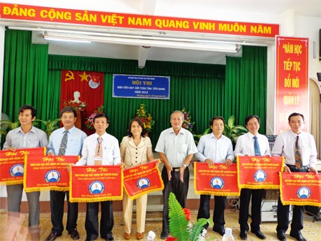 Ông Trần Văn Trí, Phó Giám đốc Sở GD-ĐT tặng cờ lưu niệm cho các đơn vị tham gia hội thi.