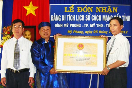 Ông Nguyễn Tấn Phong, Phó Giám đốc Sở VH-TT&DL trao Bằng công nhận cho đại diện Ban Hội Hương đình. 