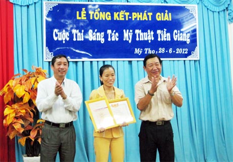 Ông Nguyễn Ngọc Minh (Giám đốc Sở VH-TT-DL) và ông Nguyễn Huỳnh Anh (Chủ tịch Hội VH-NT tỉnh) trao giải Nhất cho tác giả Ngọc Lành.