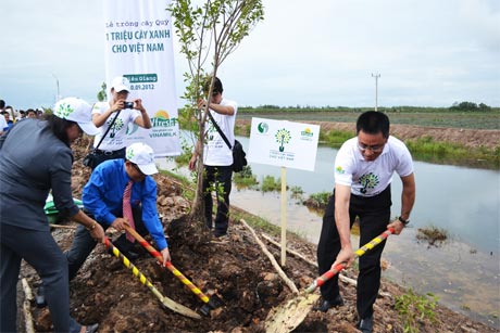 Phó Chủ tịch UBND tỉnh Trần Kim Mai cùng đại diện Công ty CP Sữa Việt Nam trồng cây xanh tại xã Thạnh Tân (Tân Phước).