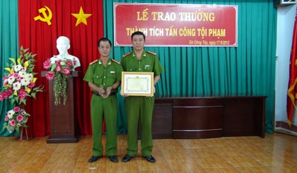 Đại tá Nguyễn Văn Lộc (bên trái) trao thưởng cho đơn vị tham gia phá trường gà ở Gò Công Tây. Ảnh: Thanh Phong