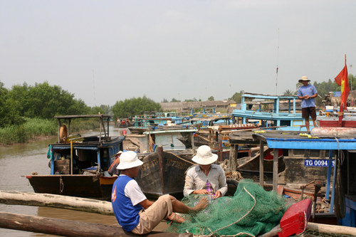 Ngư dân Gò Công vá lưới chuẩn bị ra khơi đánh bắt hải sản. Ảnh: N.Hữu