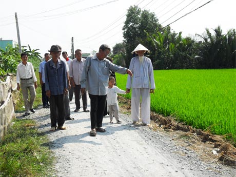 Ông Mai cùng bà con khảo sát tuyến đường giao thông ấp.