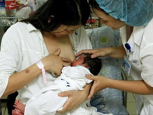 Nhân viên y tế Bệnh viện Phụ sản TW hướng dẫn sản phụ cho trẻ bú mẹ ngay giờ đầu sau khi sinh. Ảnh: TTXVN