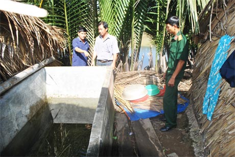 Chú Nguyễn Văn Đước (bên trái) cùng cán bộ, chiến sĩ Ban Chỉ huy Quân sự huyện khảo sát hầm đã được hộ dân mang về đựng nước sinh hoạt.