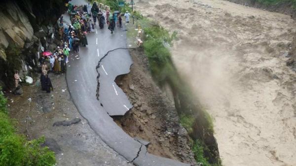 Người dân và du khách bị cô lập bên con đường bị sạt lở tại bang Uttarakhand - Ảnh: AFP