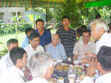 Ông Phan Văn Quận (trái) và ông Đào Minh Hải chủ tiệc (phải) đứng sau bàn tiệc  cùng bà con nhân dân chung vui hoàn thành sớm đường Thống Nhất.