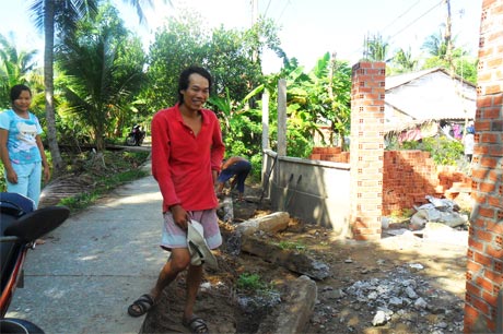 Anh Tuấn Anh đang xây lại hàng rào mới và nhân dân phấn khởi chặt cây để giao mặt bằng.