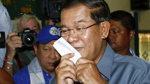 Thủ tướng Hun Sen hôn lá phiếu bầu tại điểm bầu cử Takhmau, Phnom Penh ngày 28-7. (Ảnh: AP)