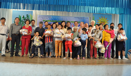 Các đại biểu cùng trao quà cho các em khuyết tật ở xã Phước Thạnh.