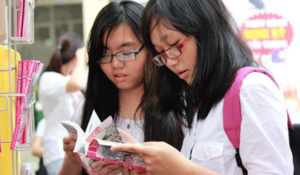 Girls read comic books on the sidelines of an opening ceremony of the institute - Photo: Thanh Hoa  Girls read comic books on the sidelines of an opening ceremony of the institute - Photo: Viet