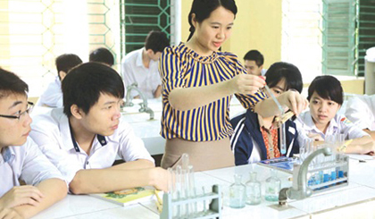 A teacher helps students during a chemistry lesson at Hung Vuong High School in the northern province of Phu Tho. The National Council of Education and Human Resources Development has called for reforms in all areas of education, from curricula and textbooks to the organisation of high school graduation examinations. — VNA/VNS