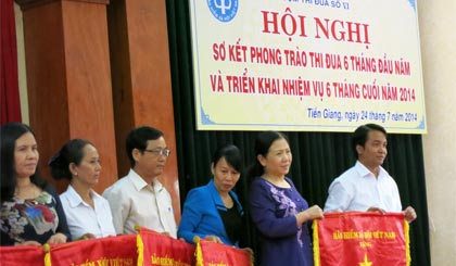 Ông Nguyễn Văn Hoàng, Phó Giám đốc BHXH TP. Mỹ Tho nhận Cờ  thi đua , do Phó Tồng Giám đốc BHXH Việt Nam Đỗ Thị Xuân Phương trao.