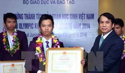 Thứ trưởng Bộ Giáo dục và Đào tạo Phạm Mạnh Hùng tặng bằng khen cho các em học sinh đoạt giải. (Ảnh: Quý Trung/TTXVN)