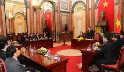 State President Truong Tan Sang meets with representatives of the 63 businesses winning the Vietnam National Trademark Award 2014 in Hanoi on December 25. (Image credit: baocongthuong.com.vn)