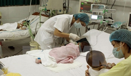 A medical worker take care of a child patient (Photo: VNA)