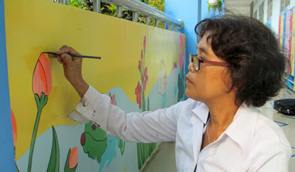 Chị Lê Huân trang trí tranh tường cho Trường Mẫu giáo  xã Long Tiên.