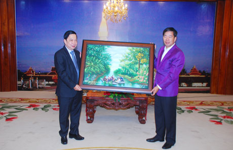 Tran The Ngoc, Secretary of the provincial Party Committee , offered a souvenir to Sinlavong Khoud Milling Thone, Vientiane Party Committee Secretary and Lord Mayor.