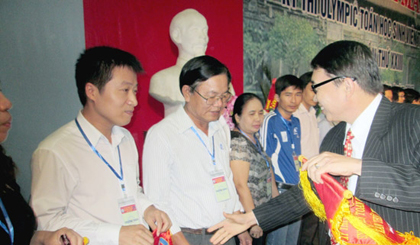 The organising board presents flowers and souvenir flags to representatives of the universities, colleges. (Photo:SGGP)