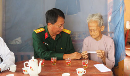 Colonel Tran Van Lan presented gift to Dinh Thi Net, mother of martyr.