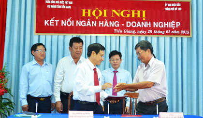 Đại diện các ngân hàng thương mại ký kết hợp đồng  tín dụng với các DN vào sáng 28-5.