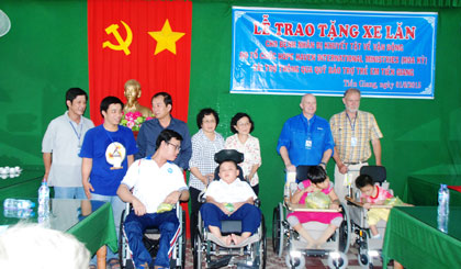 Lãnh đạo địa phương và đại diện nhà tài trợ trao xe cho trẻ em khuyết tật