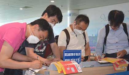   Korean passengers fill in heath declaration forms at the Noi Bai International Airport. (Photo: VOV)