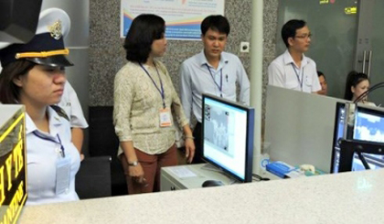 Health officials check the body temperature of passengers arriving at Da Nang International Airport. (Image credit: VOV)