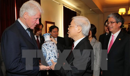 Tổng Bí thư Nguyễn Phú Trọng tặng quà lưu niệm cho Cựu Tổng thống Hoa Kỳ Bill Clinton. Ảnh: Trí Dũng/TTXVN